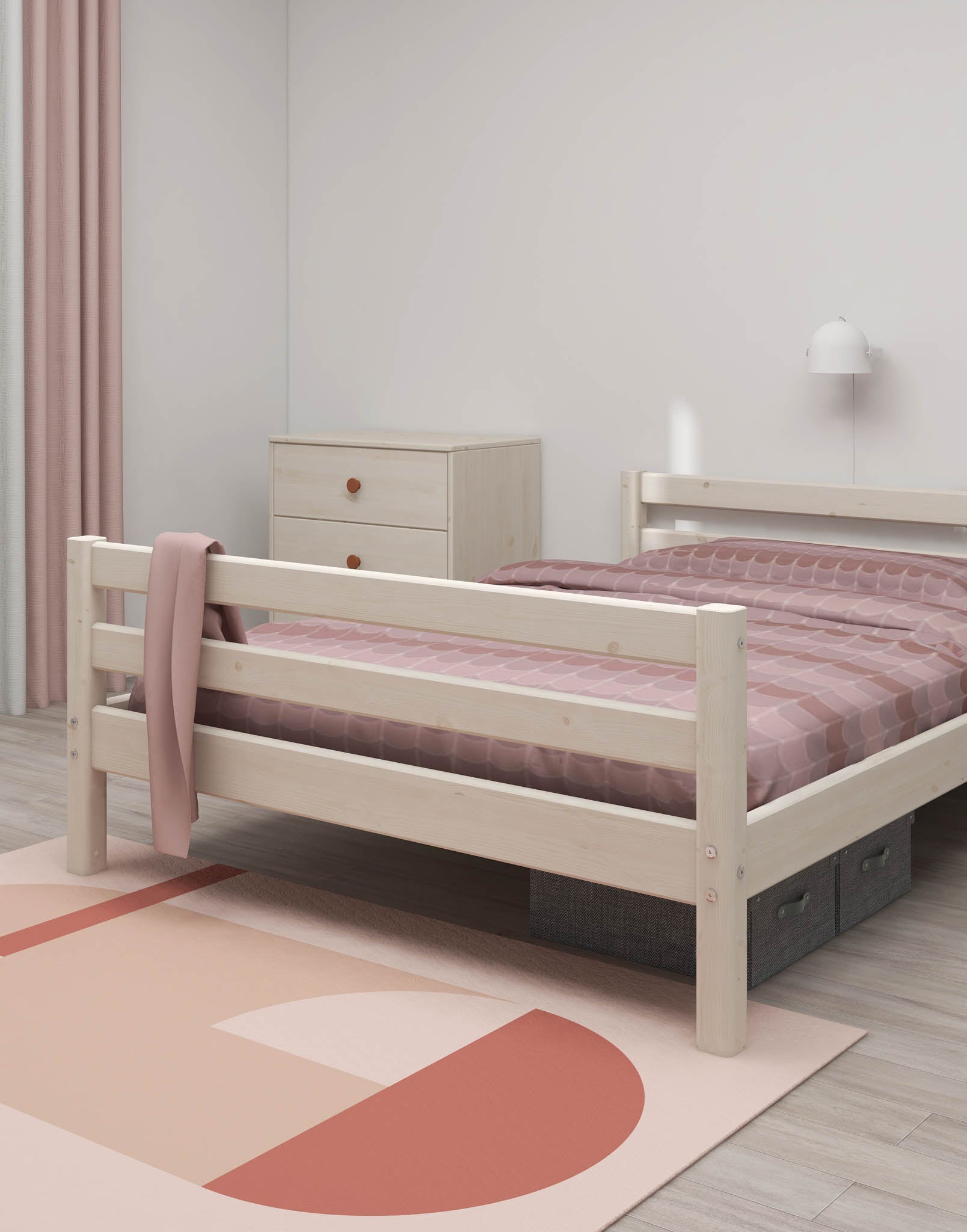 Ein weißes Einzelbett „FLEXA“ aus der CLASSIC-Kollektion in einem minimalistisch eingerichteten Kinderzimmer mit rosa Bettwäsche, Kommode und Teppich.