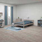 FLEXA single bed, grey, in a minimalist child’s bedroom with blue accents; child-safe rounded edges visible.