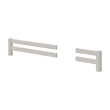 Lot de deux barrières de sécurité FLEXA grises à panneaux séparés, lune longue et lautre courte, présentées sur un lit blanc conçu pour la sécurité des enfants.