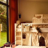 Lit mezzanine FLEXA et coussin dorsal ROSE dans une chambre denfant avec une peluche, une fenêtre et des bords arrondis visibles pour la sécurité des enfants.