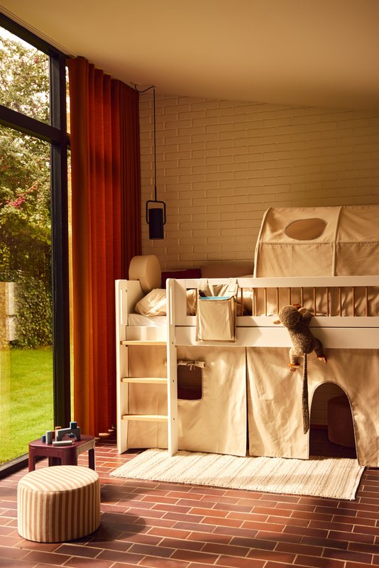 Lit mezzanine FLEXA et coussin dorsal ROSE dans une chambre denfant avec une peluche, une fenêtre et des bords arrondis visibles pour la sécurité des enfants.