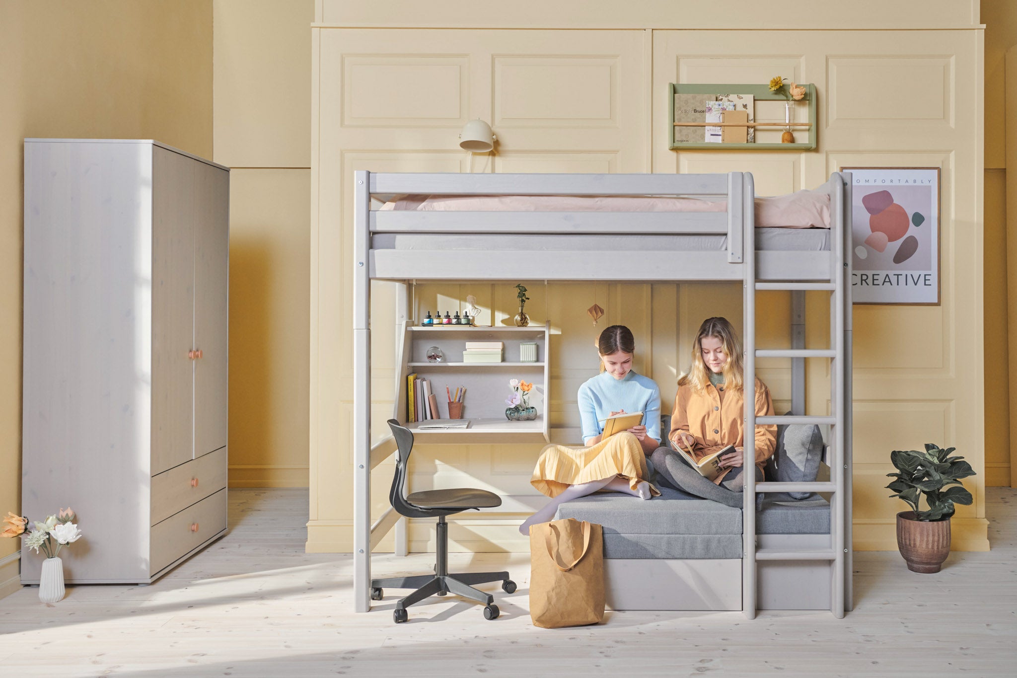 FLEXA grey High Bed with sofa, ladder and safety rail in a bright room with bookshelves, plants and wall art.